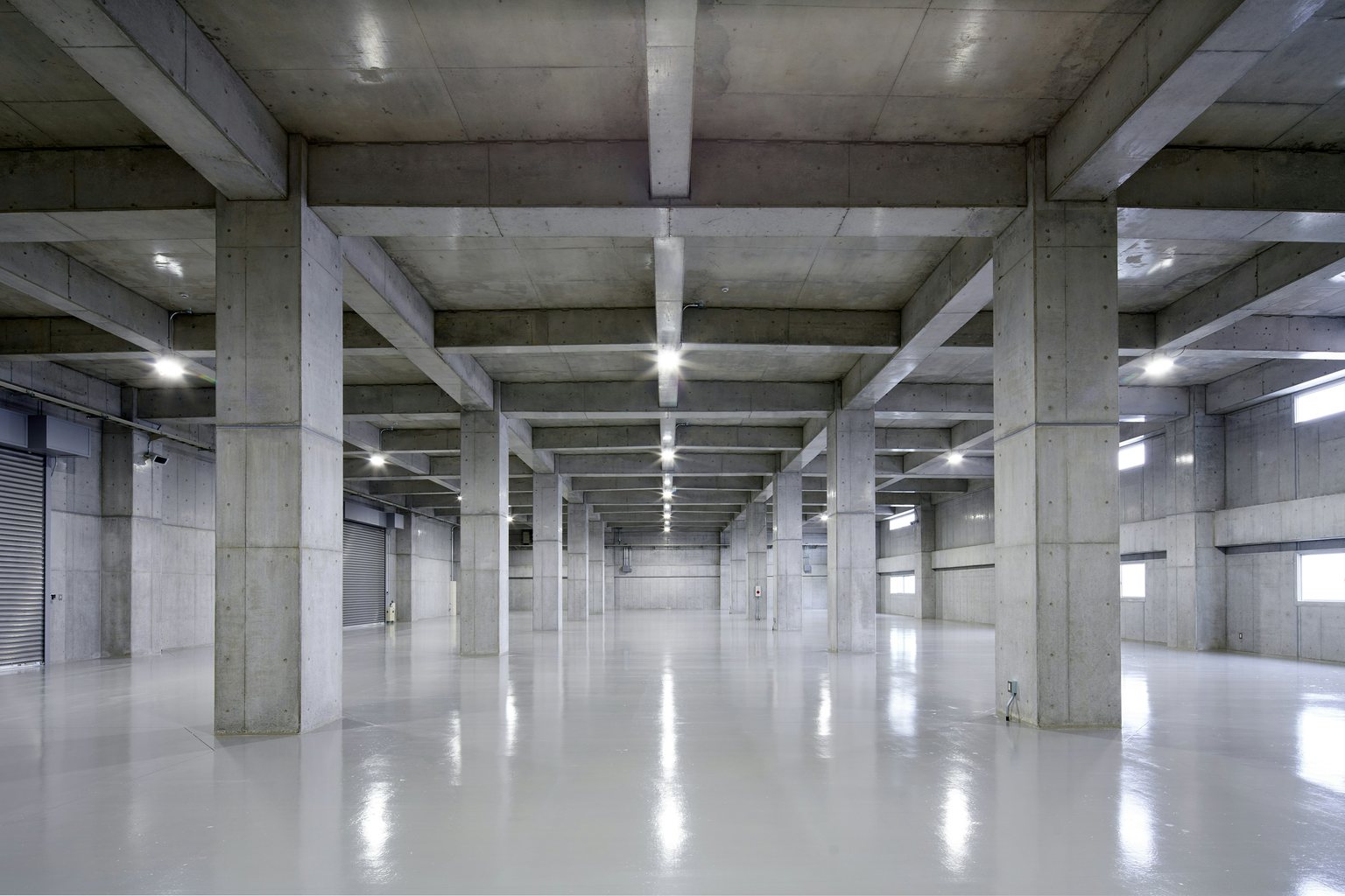 Industrial hall with concrete columns and a glossy gray floor
